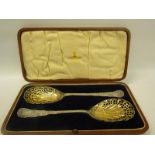 A pair of late Victorian silver sifting spoons with pierced gilt shell shaped bowls and foliate