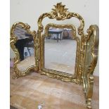 A late 19c/early 20c gilt wood and stucco triptych mirror of rococo form with central swing mirror