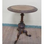 A Victorian walnut circular pedestal tripod table, the top with two outer carved bands of scrollwork