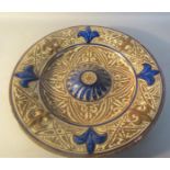 A Spanish Hispano Moresque circular dish, leaf moulded with a central boss with fleur de lys border,