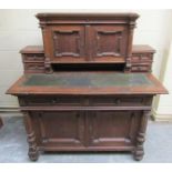 A Victorian oak writing desk with upper cabinet section, having a central cupboard enclosed by two