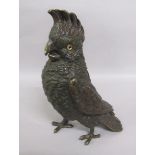 A cast patinated bronze figure of a cockatoo with glass eyes, standing 25cm h. (One leg fitting to