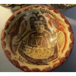 A probably 12c Persian pottery bowl decorated with a hunter with two hawks in shades of brown and