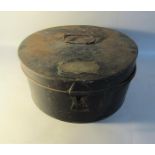 An early 19c black painted toleware storage tin of circular form and having centre carrying handle