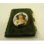 A late Victorian velvet folding needle case, the cover with an oval porcelain panel decorated with
