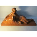 A French Art Deco terracotta figure of a reclining nude lady by George Maxin, she reclining and