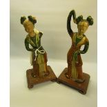 A pair of Tang Dynasty style pottery figures of ladies in costume of the period, green and brown