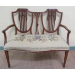A late 19c Hepplewhite style two seater sofa with swag carved shield shaped back, having open arms