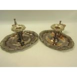 A pair of 19c Sheffield plate chamber sticks, the oval pans with shell and leaf cast borders, the