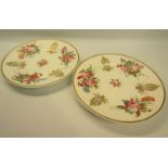 A pair of 19c Nantgarw porcelain plates, hand painted and gilded with floral sprays including roses,