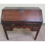 A late 18c oak bureau with fall front and interior fitted with five short drawers under ten pigeon