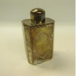 A late Victorian silver tea canister of octagonal facet form, with scroll and leaf chased side