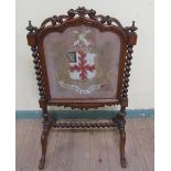 A Victorian walnut fire screen, twist carved and with a scroll and leaf carved pediment with