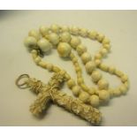 A Victorian carved white bone crucifix entwined with fruiting vine together with a white bone