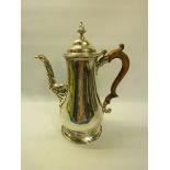 An early Victorian silver coffee pot of baluster form with carved wood scrolling handle, having a