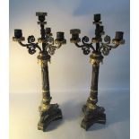 A pair of 19c patinated bronze three branch candelabrum with classical cast columns and scrolling