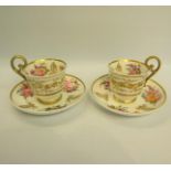 A pair of 19c Nantgarw tea cups and saucers, hand painted and gilded with floral sprays including