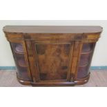A Mid Victorian figured walnut credenza with central shelved cupboard flanked by glazed curved