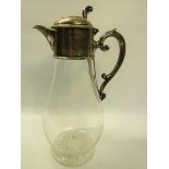 A Victorian clear glass baluster claret jug with silver mount and scrolling handle with hinged cover