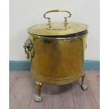 A 19c brass fuel bucket with lion mask ring pull handles and being of cylindrical form supported