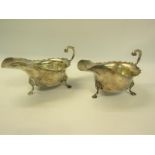 A pair of Victorian mid Georgian style silver sauce boats with open scrolling handle and each