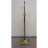 A late 19c/early 20c brass Corinthian column lamp stand of adjustable height supported on a