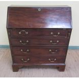 A George III figured mahogany bureau with fall front and fitted interior over four long drawers