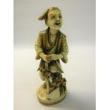 A Meiji period carved ivory figure of a wood cutter, stained and decorated, base with signed blue
