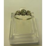 An 18ct white gold three stone diamond set ring, size M.