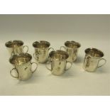 A set of six silver tyg shaped tots, each with three handles being of cylindrical form with a