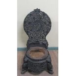 Early 19c Indian ebony low chair the base of circular form, profusely carved apron. The legs are