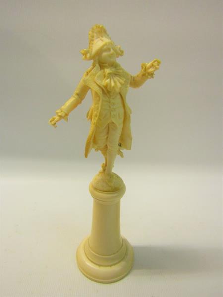 A late 19c carved ivory figure of a Dandy, supported on a tapering plinth with circular plinth.