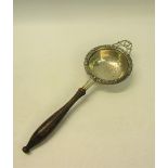 A 20c silver tea strainer with turned wood handle. Makers mark for C J Vander, London 1952. 19cms l.