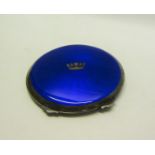An early 20c silver and blue enamel compact of circular form with hinged cover having crown motif.