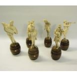 A late 19c German group of six carved ivory street musicians standing on wooden barrels, each figure