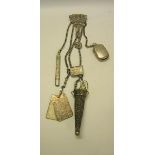 A late Victorian silver chatelaine with five chains, carrying a silver pencil, a vesta case, a stamp
