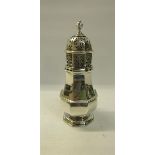 A silver sugar caster of facet baluster form with pierced dome cover and finial. Makers mark for