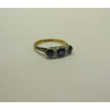An 18ct gold and platinum three stone ring, set with Sapphire and Diamonds. Ring size L.