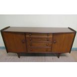 A 1970s Younger Limited teak sideboard fitted four graduated central drawers flanked by two
