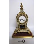 A mid 19c French mantel clock the waisted case having a glazed pendulum aperture below the dial