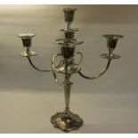 A silver four branch candelabra with central stick on a tapering column with shaped domed base,