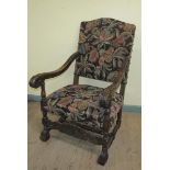A 19c walnut framed and upholstered open arm chair with bold leaf carved down swept arms, floral