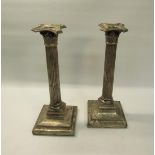 A pair of silver Corinthian column candlesticks, makers marks are rubbed. London 1910. The base is