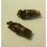 A pair of Victorian gilt copper and brass dog whistles, one with a cat wearing a bow terminal, the