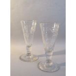A pair of early 19c English wine glasses with trumpet bowls on lobed reducing columns with dome