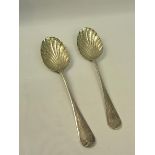A pair of 19c decorative table spoons with floral engraved shell shaped bowls and chased handles.