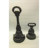 A 19c Kenrick cast iron door stop 34cms h, together with a similar 18cms h.