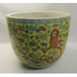 An Oriental fish bowl decorated with dragons amongst flowers on a yellow background. 37cms dia x