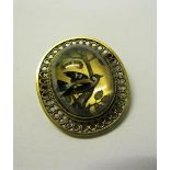 An early 20c gilt metal framed brooch featuring an encased Goldcrest. 3.5cms.