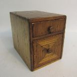 A 19c straw work miniature chest of two drawers. 8cms w x 10cms h.